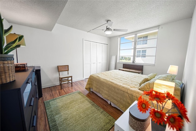 bedroom featuring a textured ceiling, a closet, baseboards, and wood finished floors