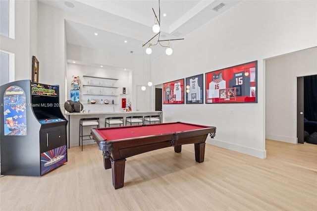 game room featuring billiards, light hardwood / wood-style flooring, and a high ceiling