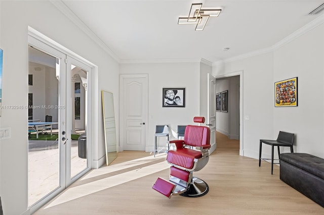 sitting room featuring crown molding, light hardwood / wood-style flooring, and french doors