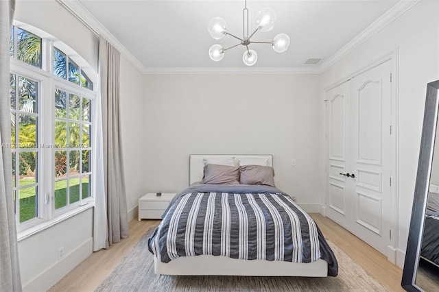 bedroom featuring multiple windows, light hardwood / wood-style flooring, and ornamental molding