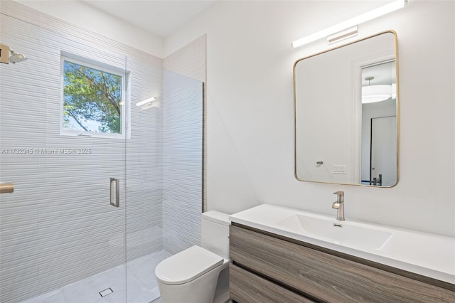 bathroom featuring vanity, toilet, and a shower with shower door