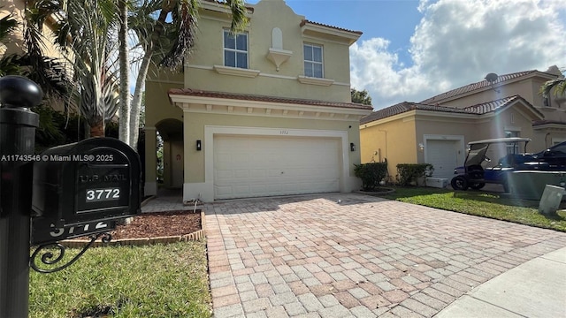 view of front facade with decorative driveway, an attached garage, and stucco siding