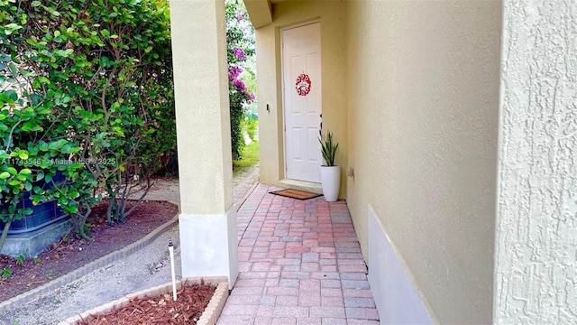 doorway to property featuring stucco siding