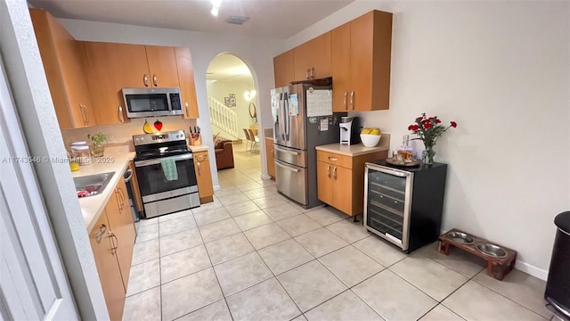 kitchen with visible vents, wine cooler, light countertops, appliances with stainless steel finishes, and arched walkways