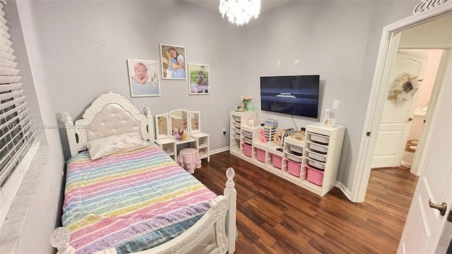 bedroom featuring baseboards, an inviting chandelier, and wood finished floors