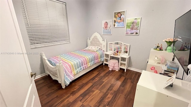 bedroom with baseboards and wood finished floors