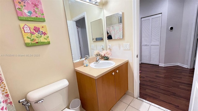 bathroom featuring tile patterned flooring, toilet, and vanity