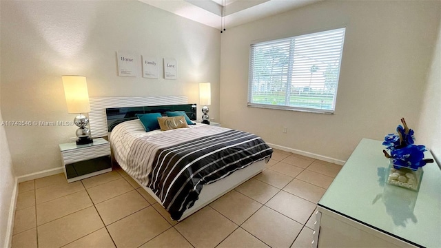 bedroom featuring light tile patterned floors and baseboards