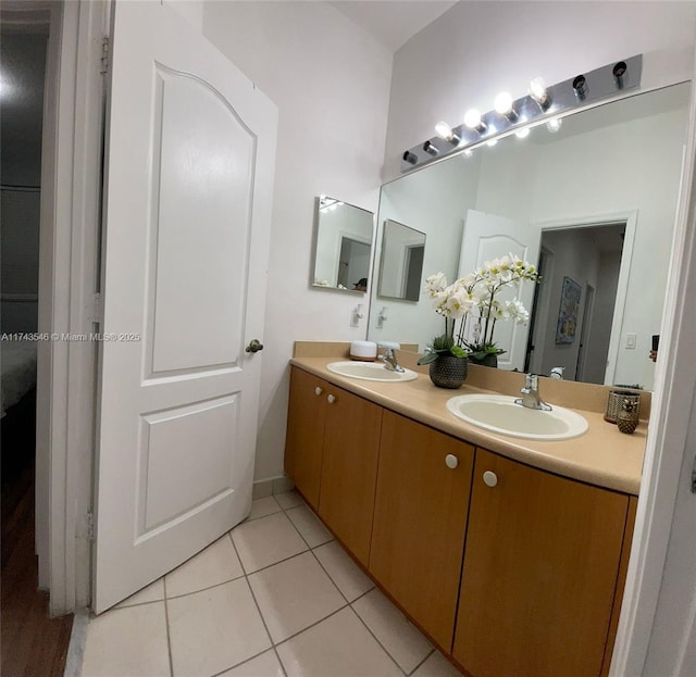 full bath with a sink, double vanity, and tile patterned floors