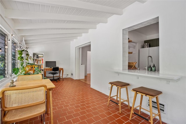 interior space with beam ceiling and refrigerator