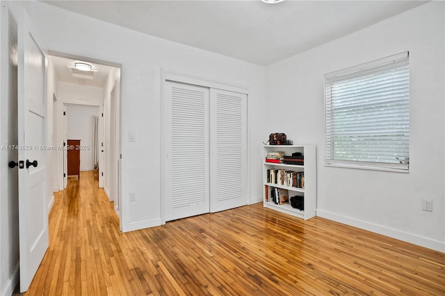 unfurnished bedroom featuring light hardwood / wood-style floors and a closet
