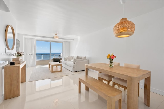 tiled dining room featuring a water view