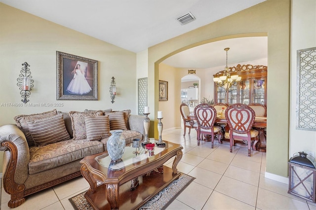 living room with an inviting chandelier, light tile patterned floors, and vaulted ceiling