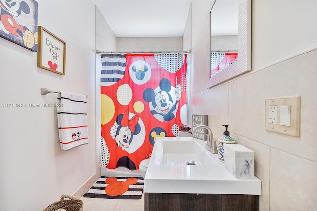 bathroom featuring tile patterned floors, vanity, toilet, and curtained shower