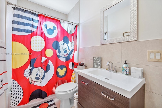 bathroom with a shower with curtain, vanity, toilet, and tile walls