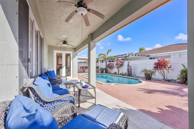 view of swimming pool featuring a patio, ceiling fan, and french doors