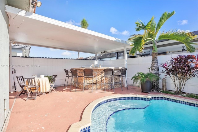 view of swimming pool featuring a patio and a bar