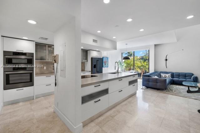 10655 NE Quaybridge Ct Unit C3, Miami, FL 33138 - kitchen with modern cabinets, black fridge with ice dispenser, white cabinetry, and recessed lighting