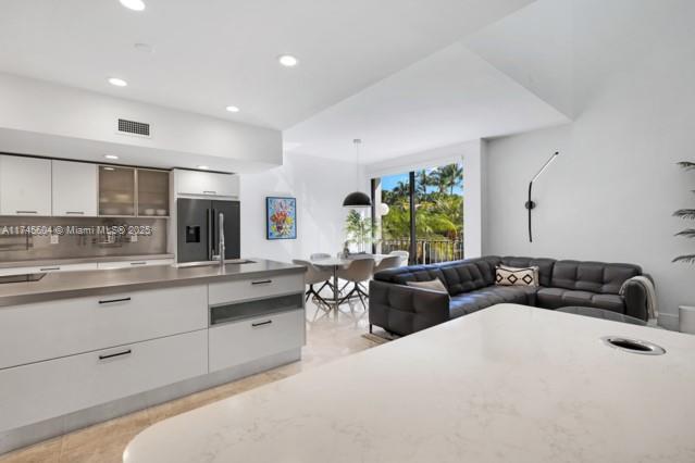 10655 NE Quaybridge Ct Unit C3, Miami, FL 33138 - kitchen with fridge with ice dispenser, modern cabinets, white cabinets, recessed lighting, and light countertops