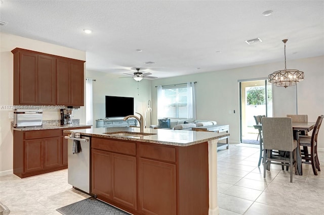 kitchen featuring pendant lighting, sink, dishwasher, a kitchen island with sink, and light stone counters