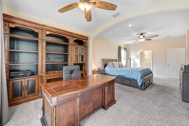 bedroom featuring light colored carpet, ceiling fan, and ensuite bathroom