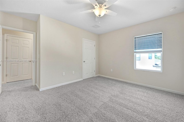 carpeted empty room featuring ceiling fan