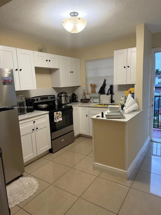 kitchen with sink, light tile patterned flooring, white cabinetry, and stainless steel appliances