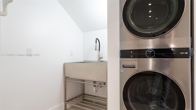 laundry room featuring stacked washer / drying machine and sink