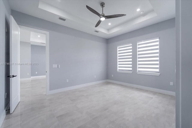 unfurnished room with a raised ceiling and ceiling fan