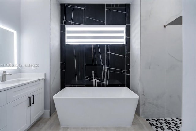 bathroom with vanity, tile walls, and a bathing tub