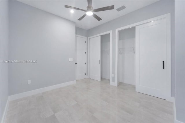 unfurnished bedroom with two closets and ceiling fan