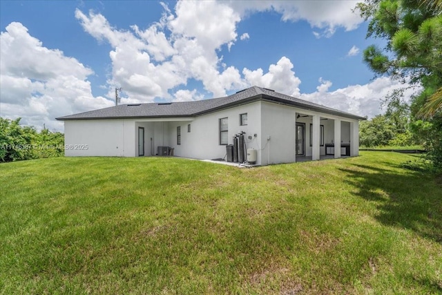 back of property with central AC unit and a lawn