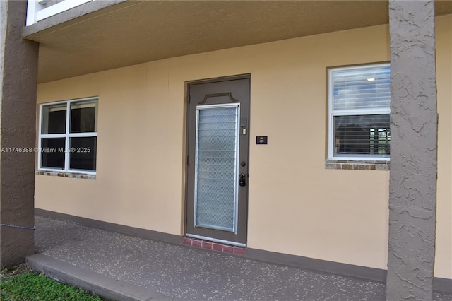 view of exterior entry with stucco siding