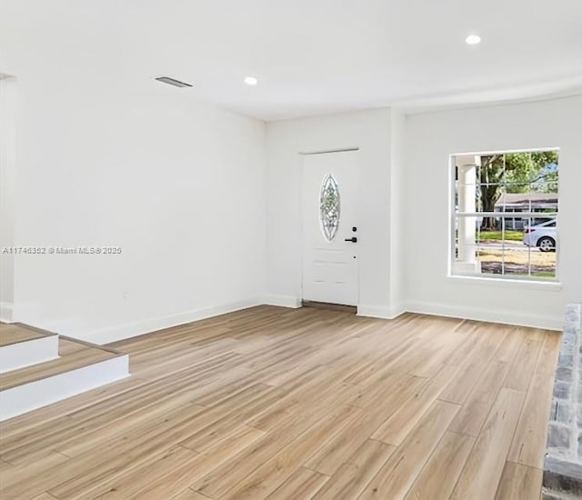 entryway with a wealth of natural light, recessed lighting, light wood-style flooring, and baseboards