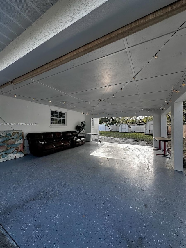 garage featuring fence and a storage shed