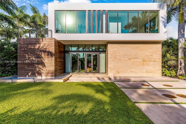 back of property featuring a yard, french doors, and stucco siding