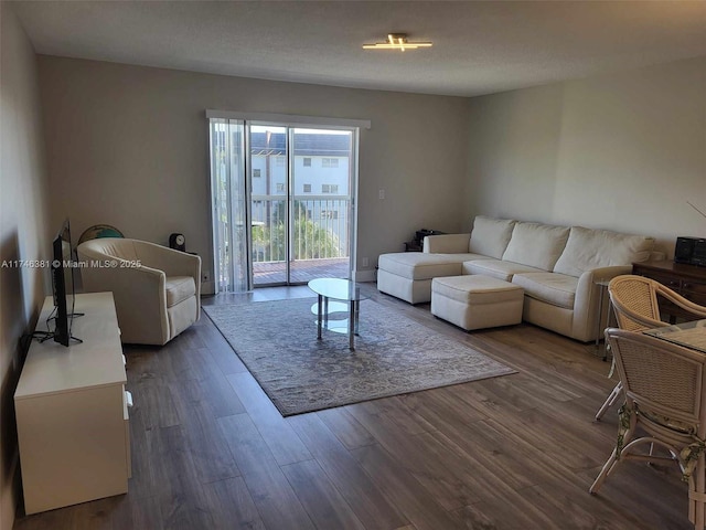 living room with dark hardwood / wood-style flooring and a textured ceiling