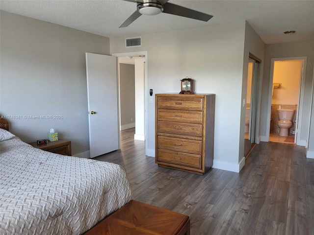 bedroom with ceiling fan, dark hardwood / wood-style floors, a textured ceiling, and ensuite bathroom