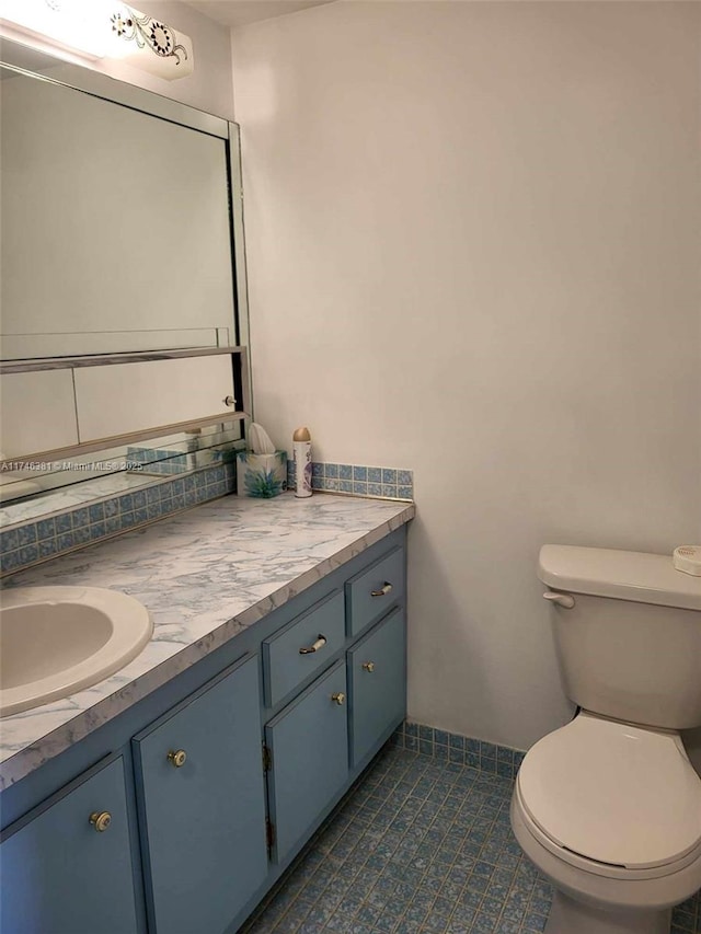 bathroom with vanity, backsplash, tile patterned floors, and toilet