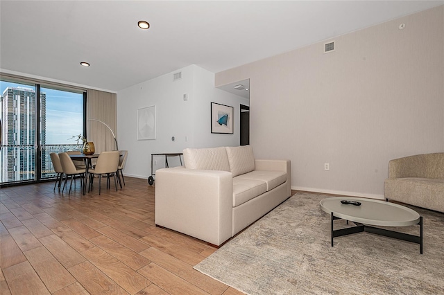 living room featuring expansive windows and light wood-type flooring