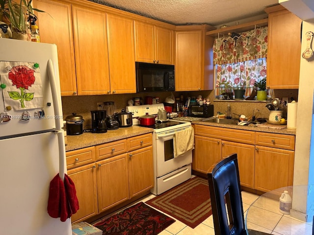 kitchen with white appliances, light tile patterned flooring, and a textured ceiling