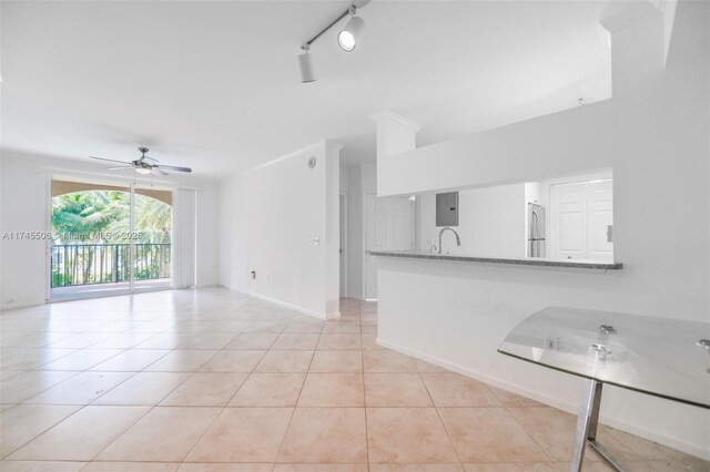 unfurnished living room with ceiling fan, rail lighting, electric panel, and light tile patterned floors