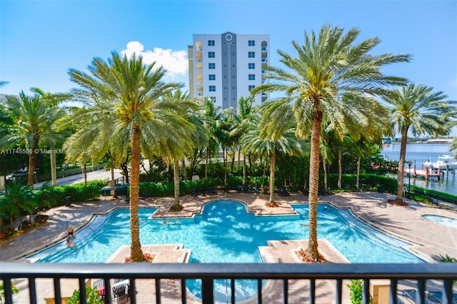 view of swimming pool featuring a patio area and a water view