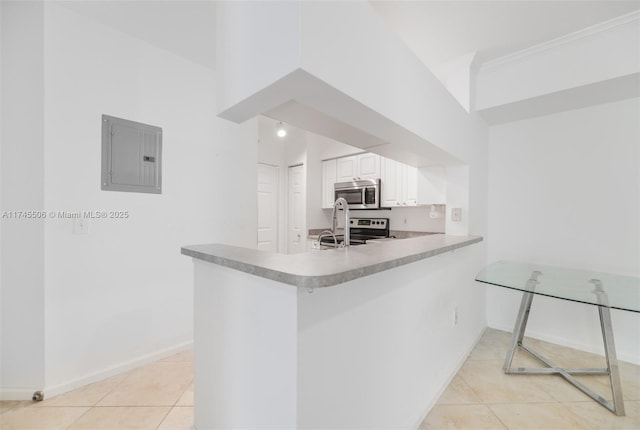 kitchen featuring light tile patterned flooring, white cabinetry, appliances with stainless steel finishes, electric panel, and kitchen peninsula