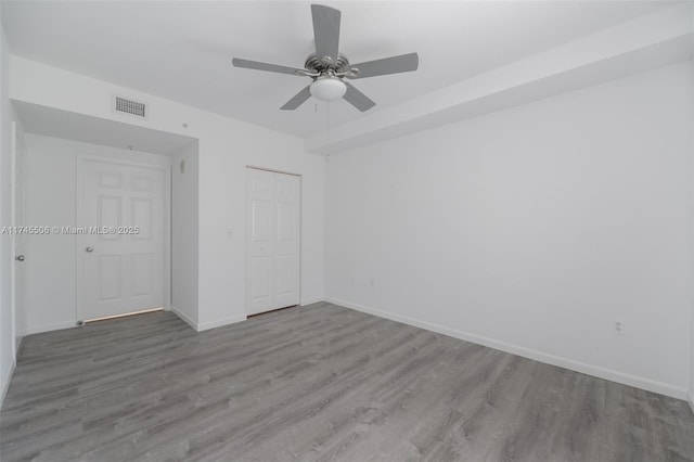 unfurnished bedroom featuring wood-type flooring, ceiling fan, and a closet