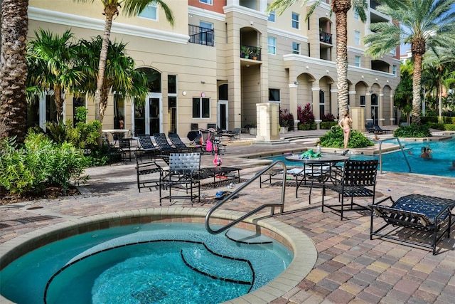 view of swimming pool with a hot tub and a patio area