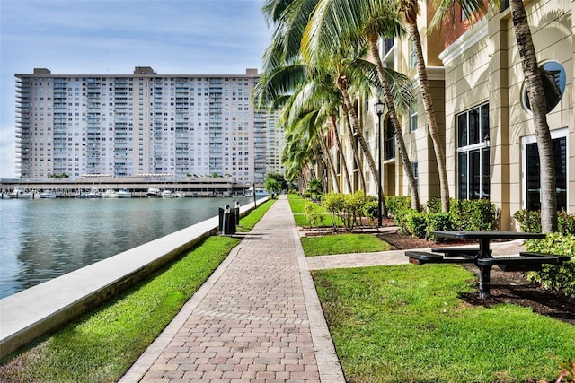 view of home's community with a water view and a lawn