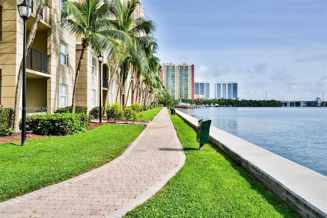 view of home's community featuring a water view and a lawn