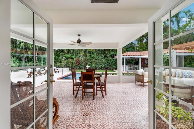 sunroom with a ceiling fan and french doors