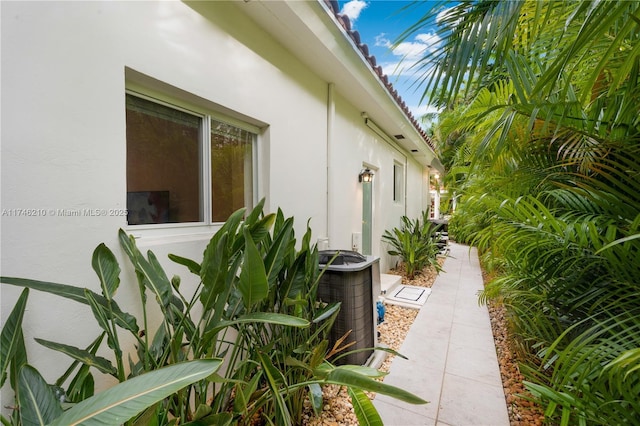 view of property exterior with central AC and stucco siding